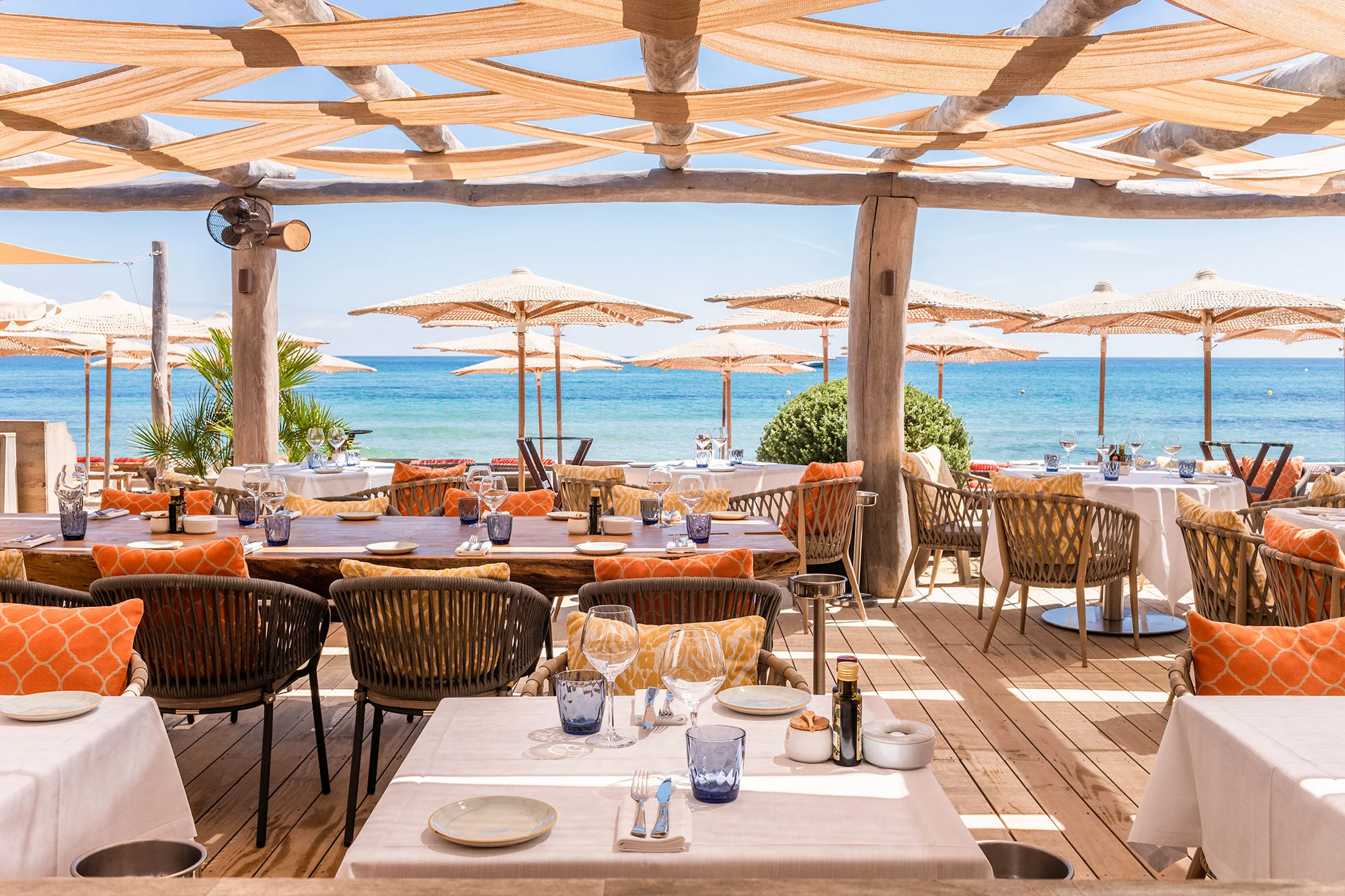 A Pampelonne beach club at lunch — wood, linen, the Mediterranean